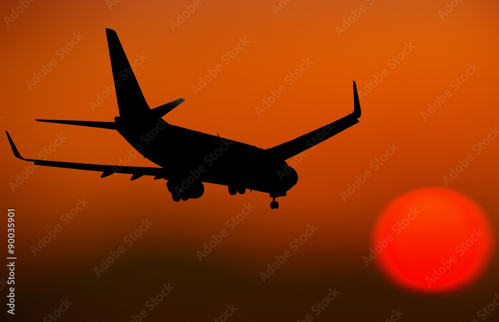Airplane Silhouette going towards the sun at dusk
