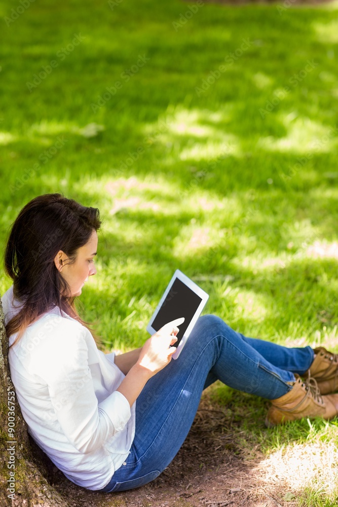 Beautiful brunette using tablet pc in the park Beautiful brunette using tablet pc in the park