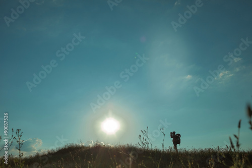 Fototapeta Naklejka Na Ścianę i Meble -  Young caucasian man with backpack walking on a green meadow