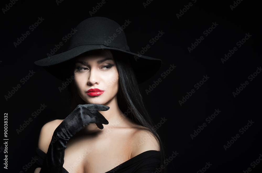 Woman in big black hat, studio portrait, dark background Woman in big black hat, studio portrait, dark background