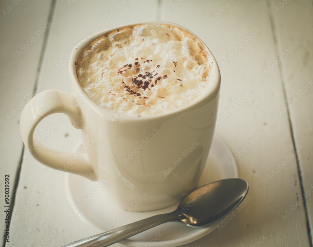 a cup of cappuccino coffee on white wood a cup of cappuccino coffee on white wood
