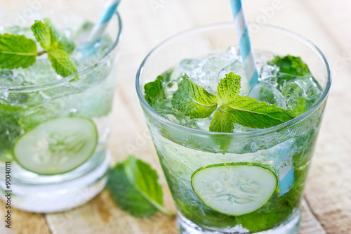 glass of cold water with fresh mint leaves and cucumber with ice