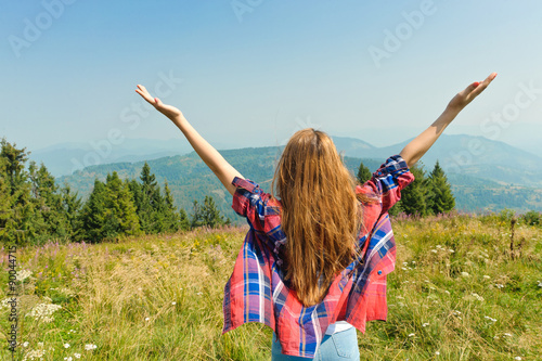Young woman looking to a sky in mountain.