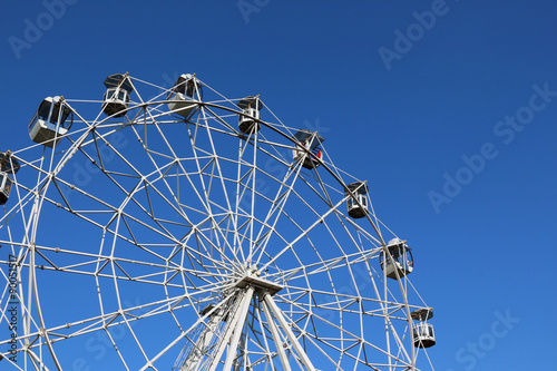 Ferris wheel against bright blue sky