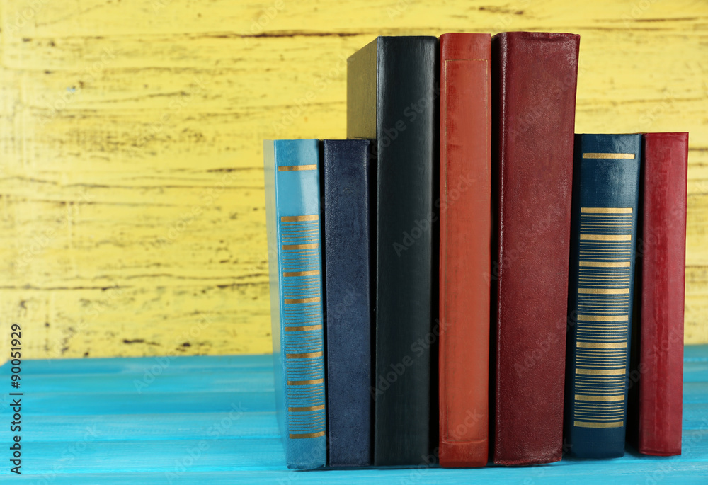 Naklejka premium Retro books on yellow wooden background