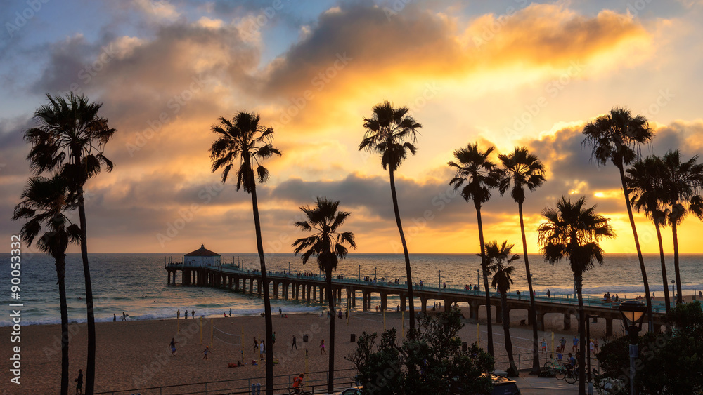 Naklejka premium Palmy nad Manhattan Beach i molo o zachodzie słońca w Los Angeles.