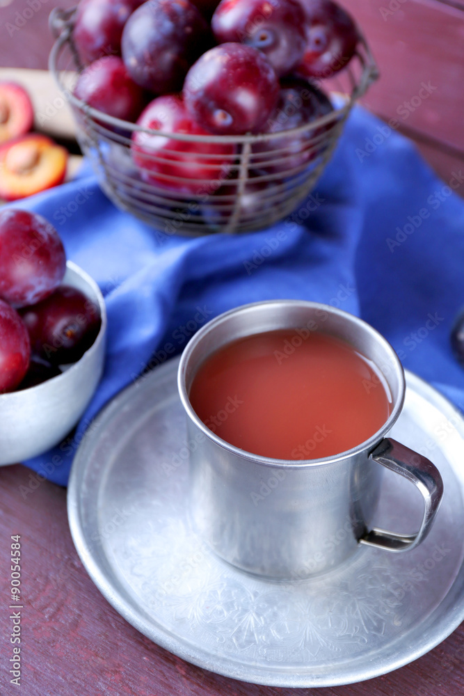 Delicious plum juice with fruits on table close up