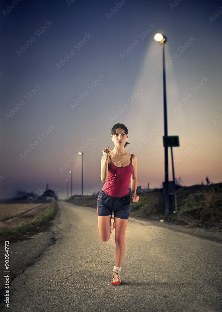 Woman running in the night StockFoto Adobe Stock