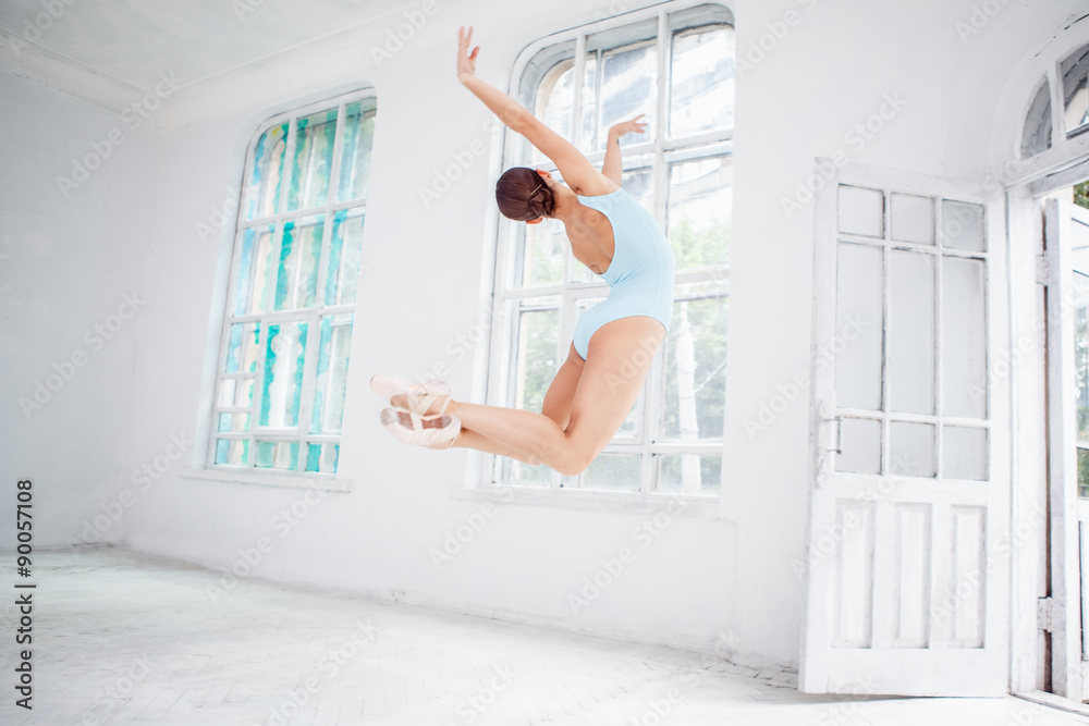 Fototapeta premium young modern ballet dancer jumping on white background