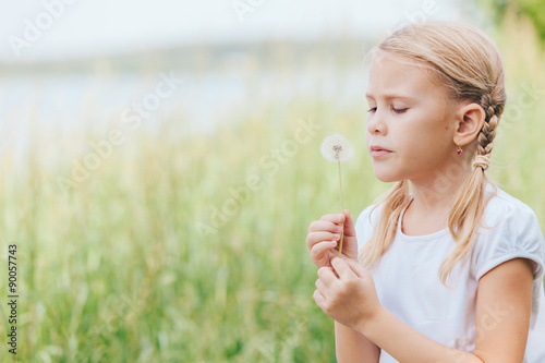 Cute little girl playing with flowers in park