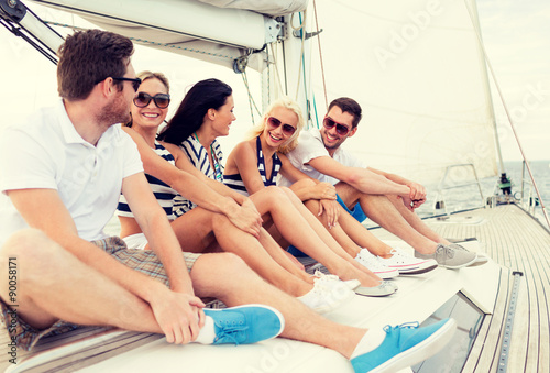 smiling friends sitting on yacht deck © Syda Productions
