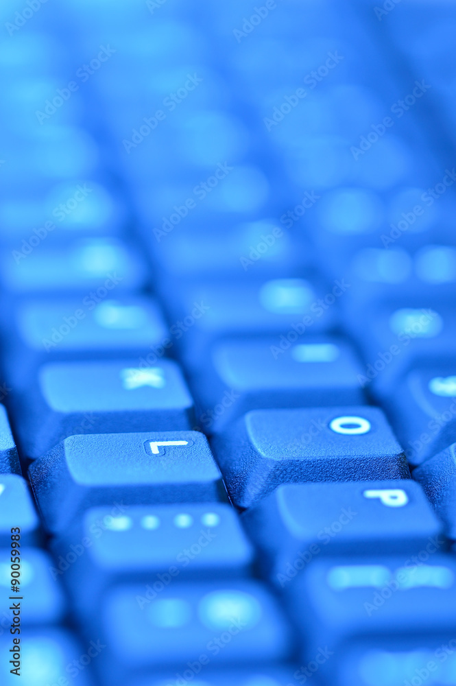 Computer keyboard. Vertical close up of mostly blurred bands of keys in blue. Computer keyboard. Vertical close up of mostly blurred bands of keys in blue.