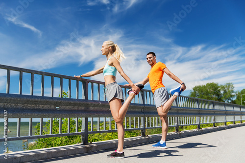 Fototapeta Naklejka Na Ścianę i Meble -  smiling couple stretching outdoors
