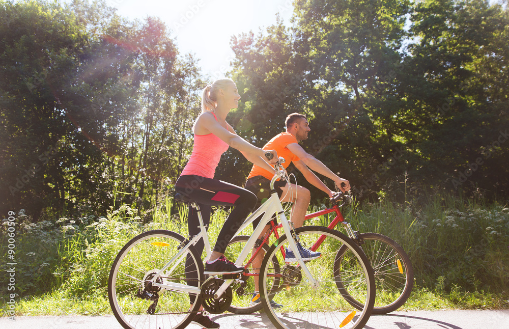 happy couple riding bicycle outdoors