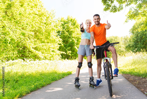 couple on rollerblades and bike showing thumbs up