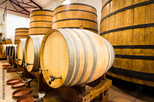 Big and small yellow barrels with iron rims and plastakovy bottles with drinks.