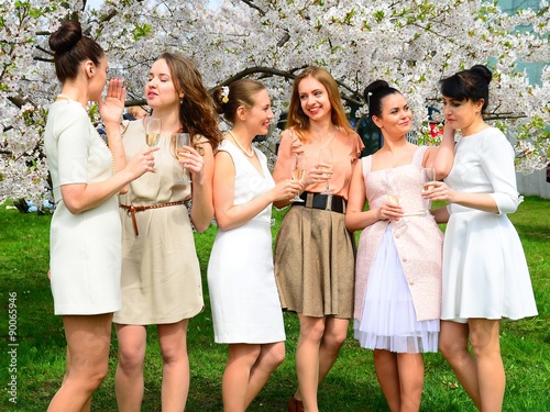 Girls with champagne celebrating in sakura's garden. © bokstaz