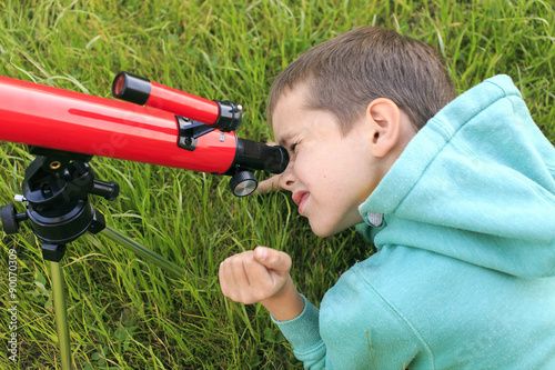 telescope. Boy studying cosmic bodies looking through a telescope