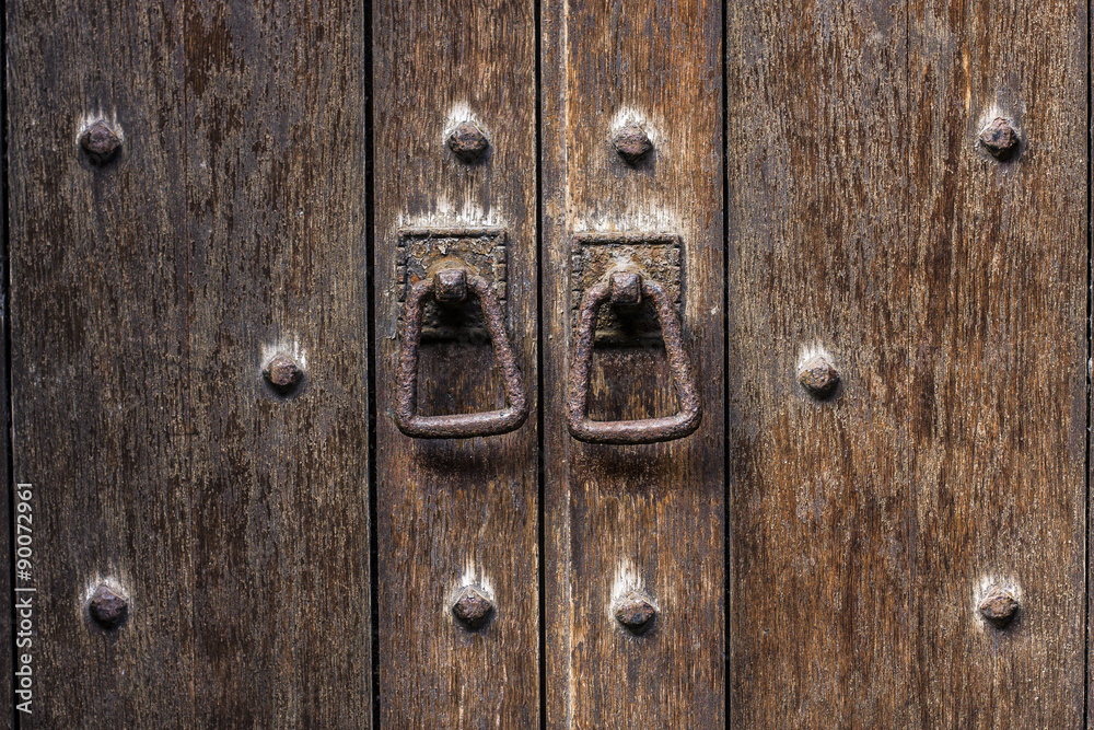 Detail close up of old wooden door with rusty door pulls. Mediaeval look Detail close up of old wooden door with rusty door pulls. Mediaeval look