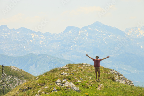 Happy young male traveler enjoying the beautiful view of Visitor mountains in Montenegro 