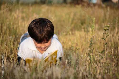 little boy reading book in the nature