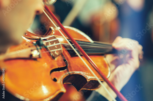Symphony orchestra on stage, hands playing violin