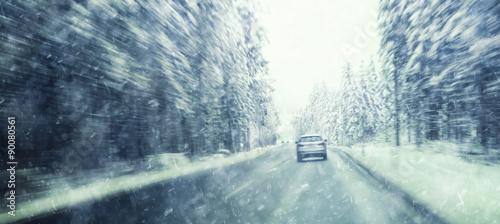 Danger and fast speed driving at the heavy snowy and icy road. Motion blur visualizies the speed and dynamics.