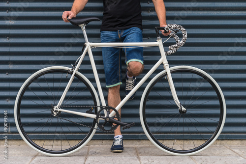 Hipster man with a fixie bike in metallic wall