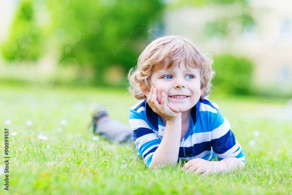 Happy child enjoying on grass field and dreaming Happy child enjoying on grass field and dreaming