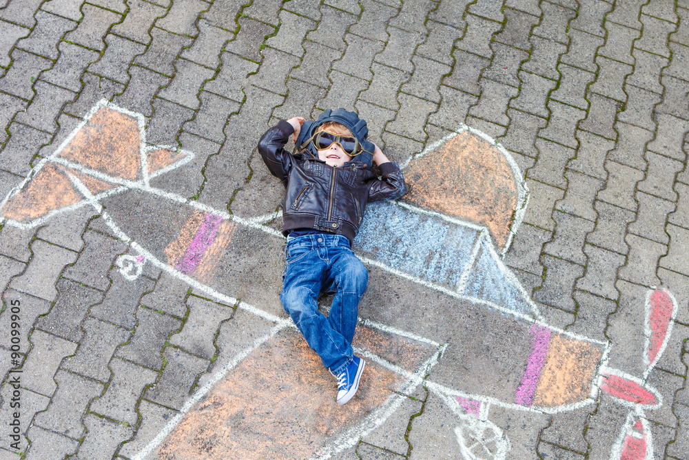 Little boy having fun with airplane picture drawing with chalk Little boy having fun with airplane picture drawing with chalk