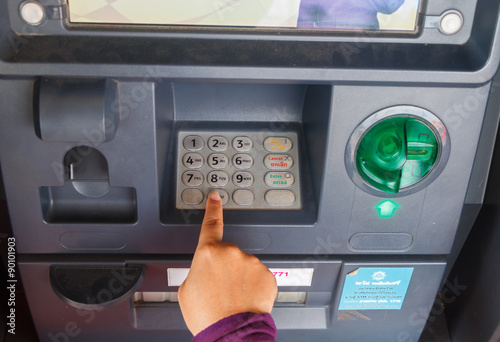 ATM close-up with woman hand photo