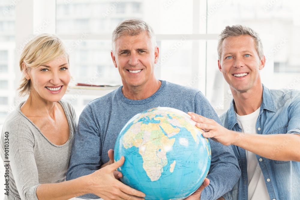 Happy business colleagues holding terrestrial globe Happy business colleagues holding terrestrial globe