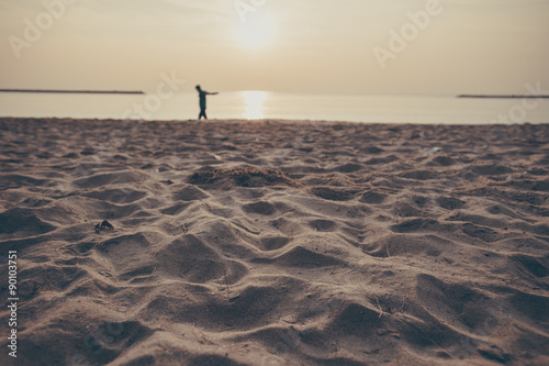 Relax walking on the wet sandy beach during sunset