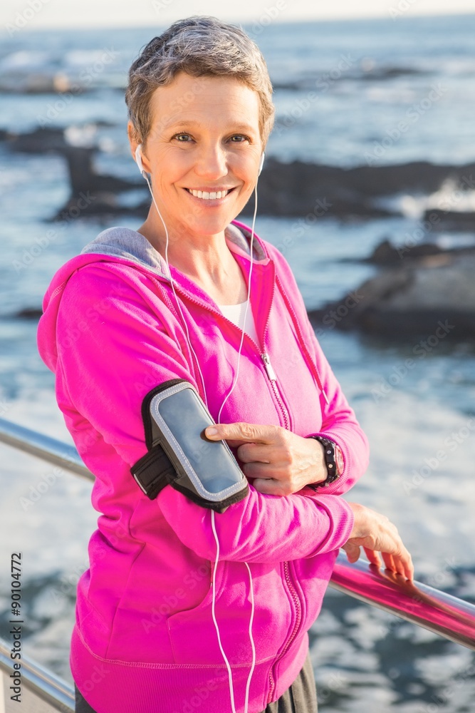 Fototapeta premium Smiling sporty woman enjoying music via headphones