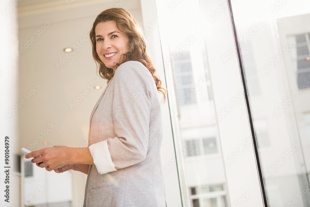 Smiling casual businesswoman holding smartphone Smiling casual businesswoman holding smartphone
