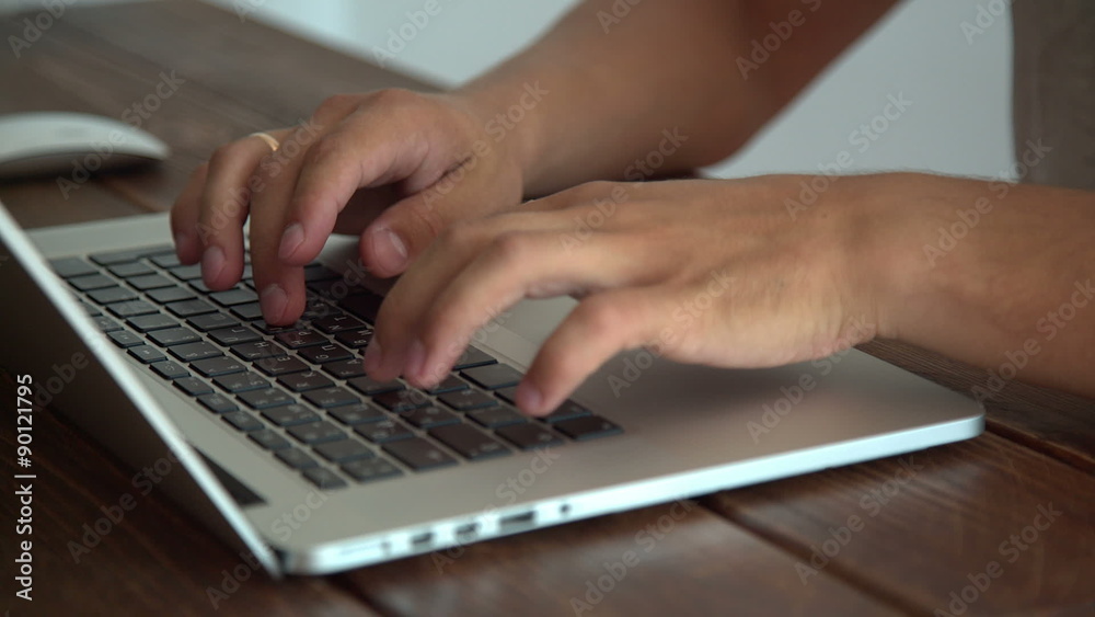 Man working with laptop placed on wooden desk Man working with laptop placed on wooden desk