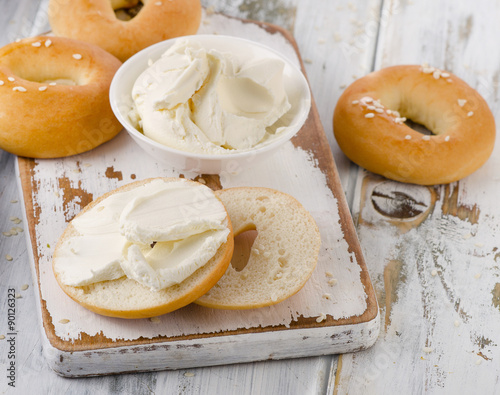 Bagels with cream cheese on  a wooden table.