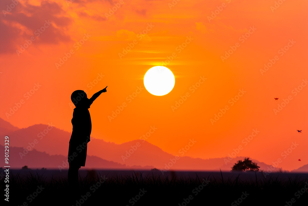silhouette of asian little boy point to the sun at sunset backgr silhouette of asian little boy point to the sun at sunset backgr