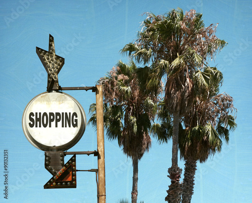 aged and worn vintage photo of shopping sign and palm trees