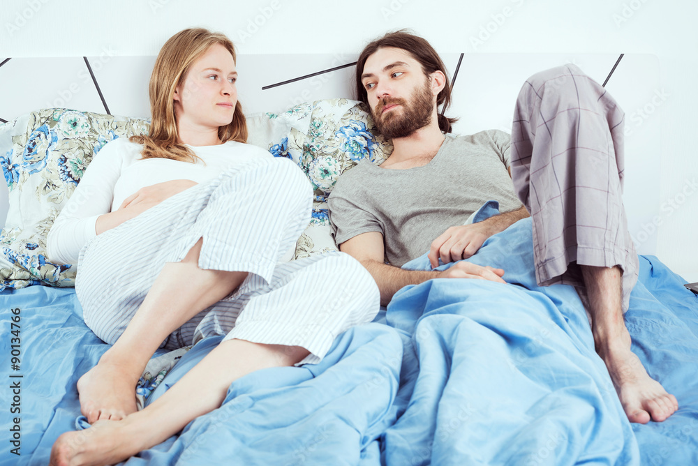 Obraz premium young loving couple smiling and talking in bed