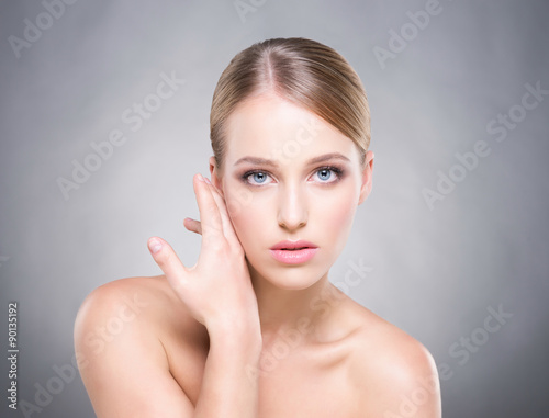 Beautiful healthy woman touching her cheek with a hand.