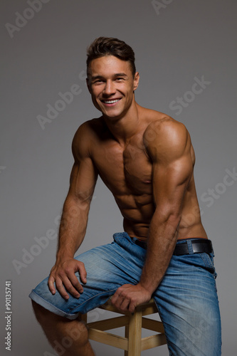 Smiling Fit Man Sitting On A Wooden Stool