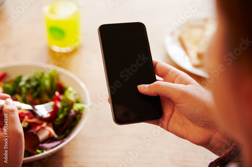 Person At Lunch Looking At To Mobile Phone