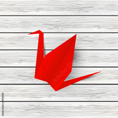 Paper origami crane on wooden background