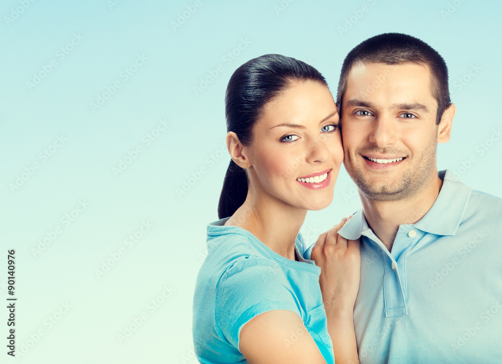 young smiling amorous attractive couple, on blue young smiling amorous attractive couple, on blue