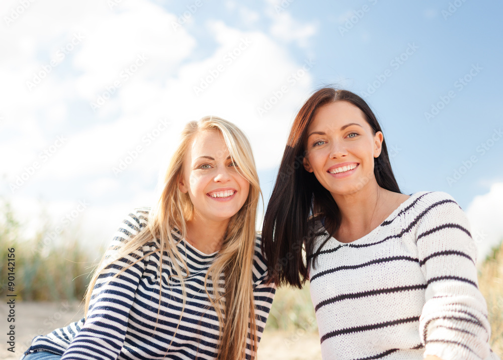 Obraz premium happy teenage girls or young women on beach