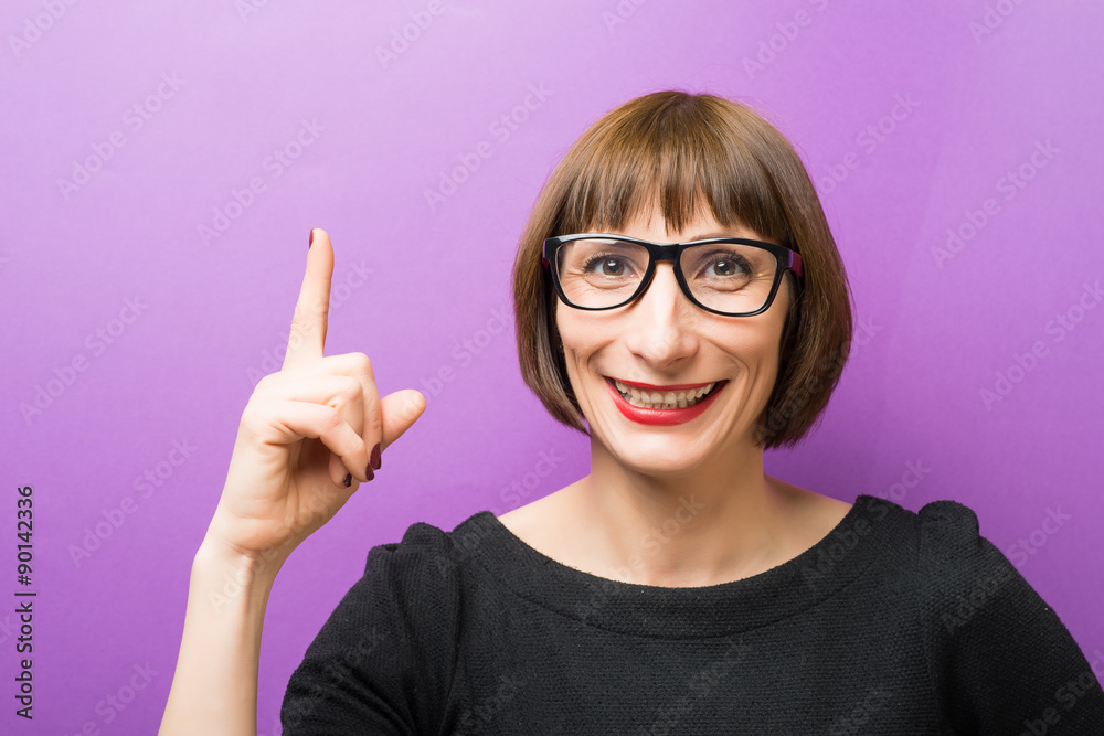 portrait of a woman with glasses forefinger up portrait of a woman with glasses forefinger up