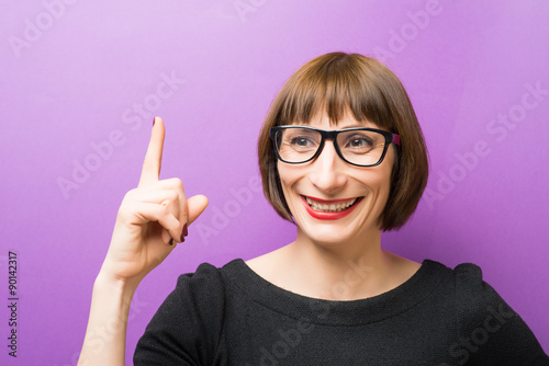 portrait of a woman with glasses forefinger up