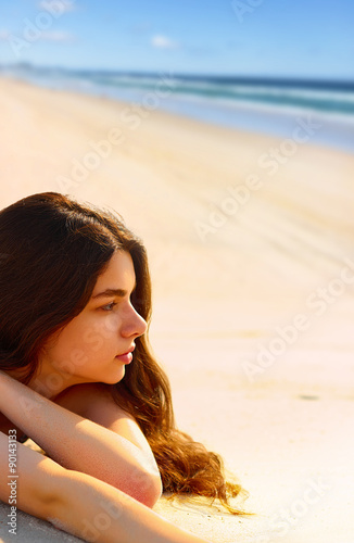 Portrait of gorgeous young woman  while relaxing on beach photo