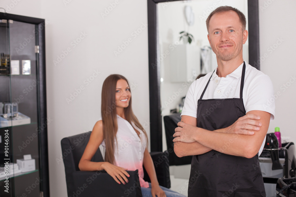 Cheerful young hairstylist is serving his customer Cheerful young hairstylist is serving his customer
